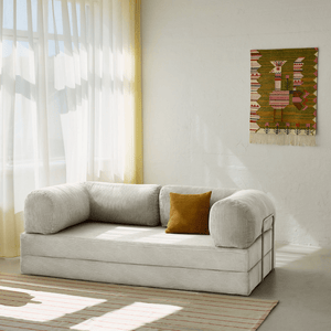 Primyhome white corduroy convertible sofa bed in a sunlit living room with minimalist decor and boho wall art